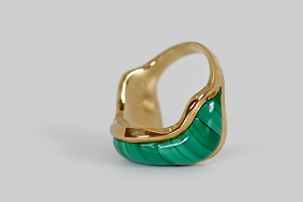 Poor Mouchette | Curated Antique Jewelry, Vintage Jewelry & Engagement Rings | Portland, Oregon | A late vintage ring, modeled in 14k yellow gold, whose curvy, wave-form face is inlaid with three plump malachite cabochons. These carefully cut malachite cabs feature beautiful bright and dark green linear figuring— they appear to be a single swath of striated stone, they fit so seamlessly together! This chubby malachite swath is framed by slender borders of high polished gold. 