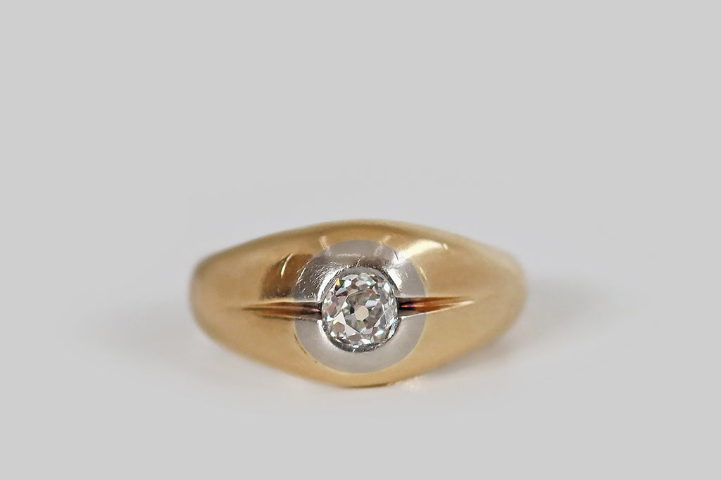 Antique Jewelry Portland, Vintage Jewelry Portland , Antique Engagement Rings | Poor Mouchette | A mid twentieth century ring, modeled in 14k yellow gold, whose gem is a chunky, flush-set, old mine cut diamond (I/J, SI1). This ring has a broad, tapering profile, and its face is softly domed, centering on a platinum target that surrounds the OMC diamond. A pair of deeply graved lines flank this hand-cut stone— their swift, flicking taper
