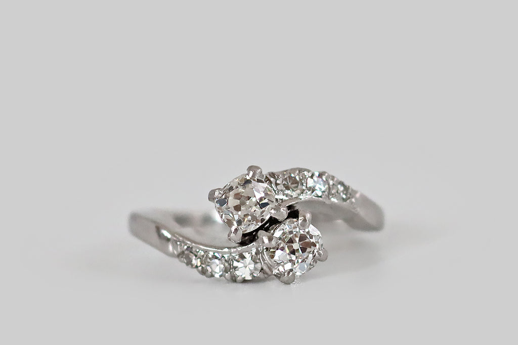 Poor Mouchette | Curated Antique Jewelry, Vintage Jewelry & Engagement Rings | Portland, Oregon | A mid-twentieth-century bypass ring, modeled in 18k white gold, whose form brings to mind a pair of comets, crossing in flight. These graceful comets have old mine cushion cut heads, and "tails" of old single cut diamonds. The primary diamonds (H-I, VS2-SI1) are held in four prong baskets. The single cuts are held in fishtail mounts, and they graduate in size as they travel down the ring's shoulders. 