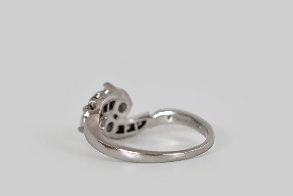 Poor Mouchette | Curated Antique Jewelry, Vintage Jewelry & Engagement Rings | Portland, Oregon | A mid-twentieth-century bypass ring, modeled in 18k white gold, whose form brings to mind a pair of comets, crossing in flight. These graceful comets have old mine cushion cut heads, and "tails" of old single cut diamonds. The primary diamonds (H-I, VS2-SI1) are held in four prong baskets. The single cuts are held in fishtail mounts, and they graduate in size as they travel down the ring's shoulders. 