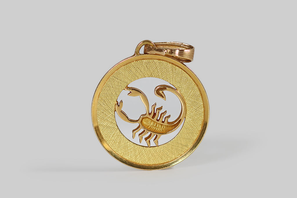 Antique Jewelry Portland, Vintage Jewelry Portland , Antique Engagement Rings | Poor Mouchette | A wonderful vintage zodiac pendant, modeled in 18k yellow gold to represent the star sign Scorpio (Oct 23 - Nov 21). This weighty, disc-shaped pendant is made with a pierced center, so that our sly scorpion appears to stand inside a shining, golden ring. The "ring" border is deep, and engraved with many fine, overlapping, needle-like lines that gave the impression of a sun's rays, beaming off the scorpion.