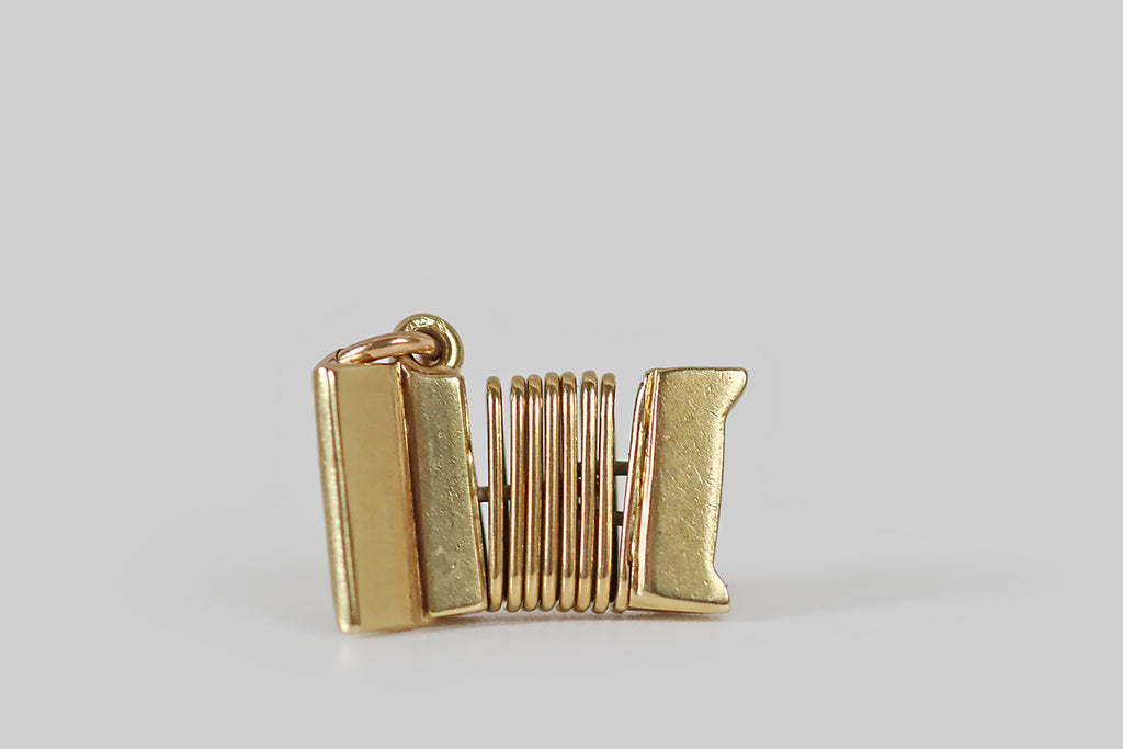 Antique Jewelry Portland, Vintage Jewelry Portland , Antique Engagement Rings | Poor Mouchette | A dainty, vintage, articulated accordion charm, modeled in 14k yellow gold by the well-known New York jewelers Sloan & Co. This sweet little accordion features a hand-painted, black and white enamel keyboard, and white enamel base buttons.
