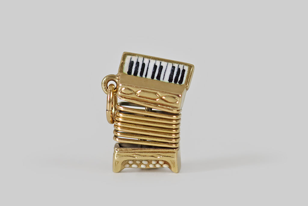 Antique Jewelry Portland, Vintage Jewelry Portland , Antique Engagement Rings | Poor Mouchette | A dainty, vintage, articulated accordion charm, modeled in 14k yellow gold by the well-known New York jewelers Sloan & Co. This sweet little accordion features a hand-painted, black and white enamel keyboard, and white enamel base buttons.