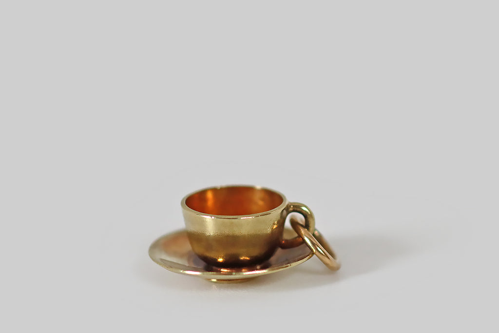 Antique Jewelry Portland, Vintage Jewelry Portland , Antique Engagement Rings | Poor Mouchette | A dainty, vintage charm, modeled as a teacup and saucer, in 14k yellow gold. This miniature cup and saucer is beautifully made— it is well-suited to anyone who takes tea over tipple, or tipple in their tea!