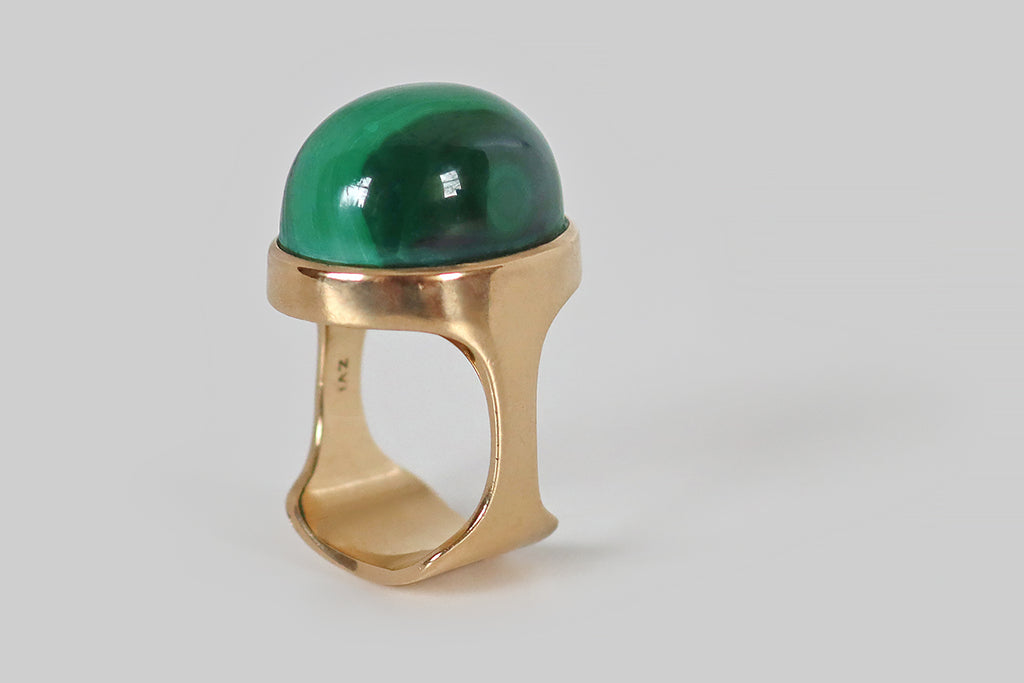 Antique Jewelry Portland, Vintage Jewelry Portland , Antique Engagement Rings | Poor Mouchette | A seriously cool, mid twentieth century modernist ring, fabricated in 14k yellow gold, whose gem is a high-dome malachite cabochon. This malachite gumdrop is seated in a smooth bezel, atop the ring's sculptural, cutaway shank. It is beautifully figured with vibrant, alternating, light-and-dark-green bands