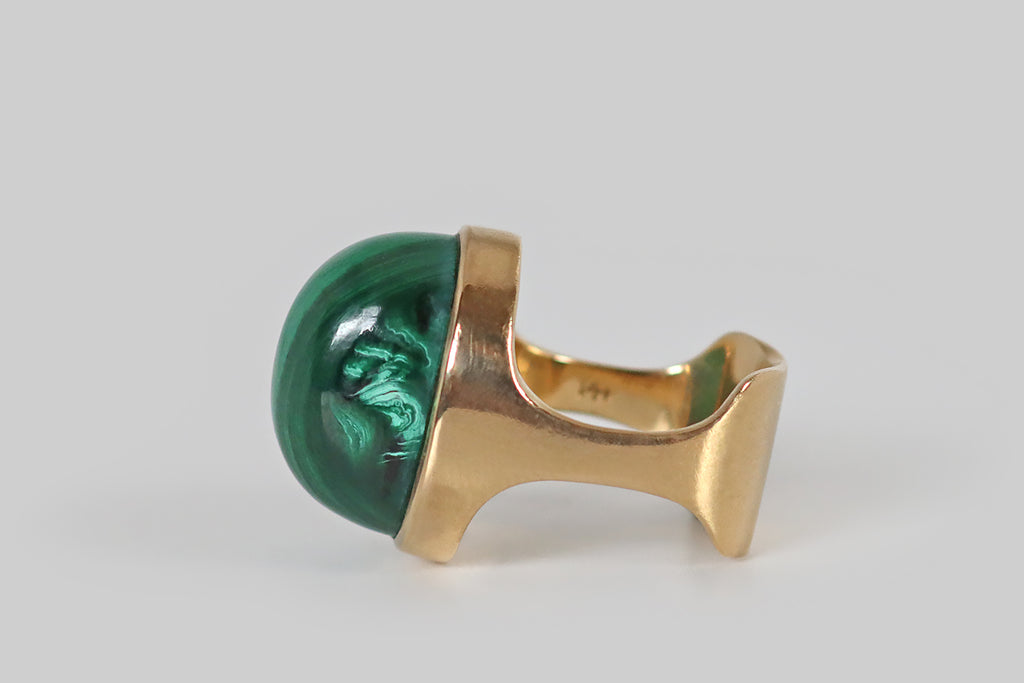 Antique Jewelry Portland, Vintage Jewelry Portland , Antique Engagement Rings | Poor Mouchette | A seriously cool, mid twentieth century modernist ring, fabricated in 14k yellow gold, whose gem is a high-dome malachite cabochon. This malachite gumdrop is seated in a smooth bezel, atop the ring's sculptural, cutaway shank. It is beautifully figured with vibrant, alternating, light-and-dark-green bands