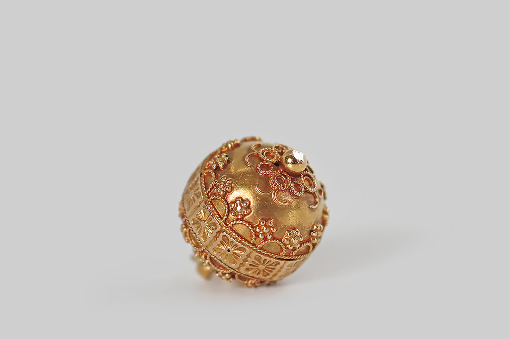 Antique Jewelry Portland, Vintage Jewelry Portland , Antique Engagement Rings | Poor Mouchette | A charming, Victorian-era, orb-shaped pendant, modeled in 14k yellow gold and finished with a rich, high-color bloom. This small orb is decorated, all over, with twisted wirework, and fine granulation that coalesces around the orb's primary feature— a band of tiles, with flower decor, that spans its meridian.