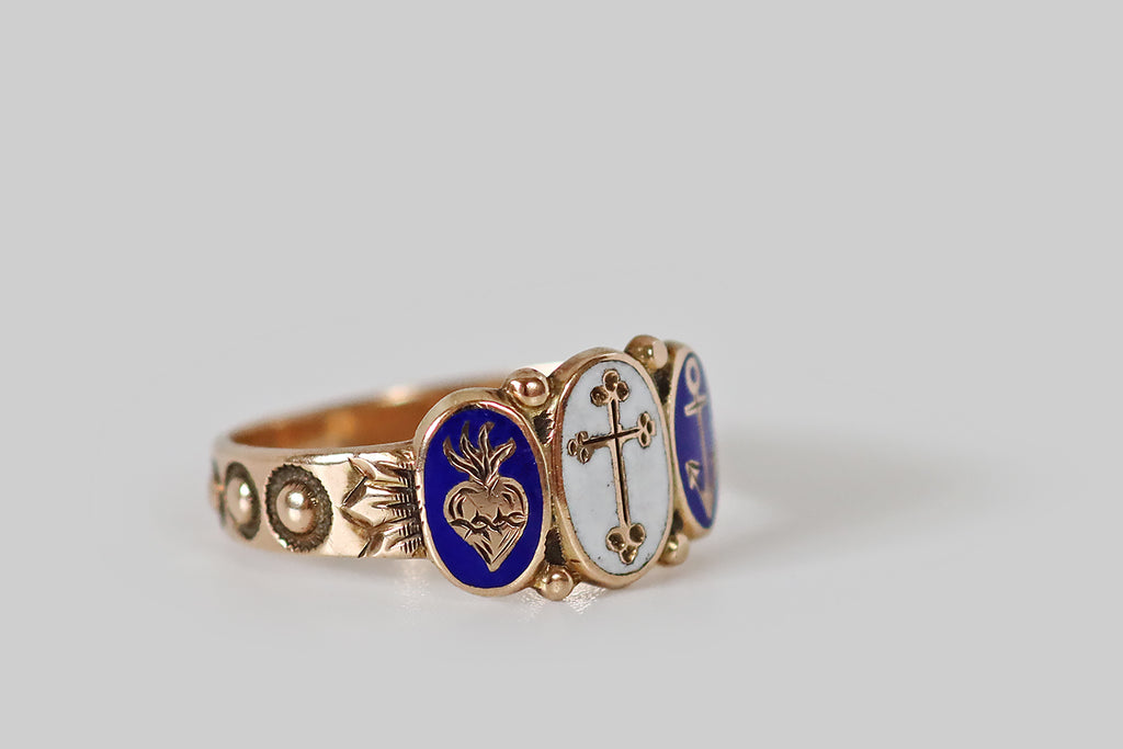 Antique Jewelry Portland, Vintage Jewelry Portland , Antique Engagement Rings | Poor Mouchette | A precious, Victorian era, cigar band ring, modeled in 10k rosy yellow gold, whose design centers on three oval plaques, decorated with white and cobalt-blue enamel. These enamels— a cross, an anchor, and a sacred heart— represent the virtues faith, hope, charity. Each symbol is raised in gold, and surrounded by a field of color. Between them (at the crown points of each plaque) balls of granulation 