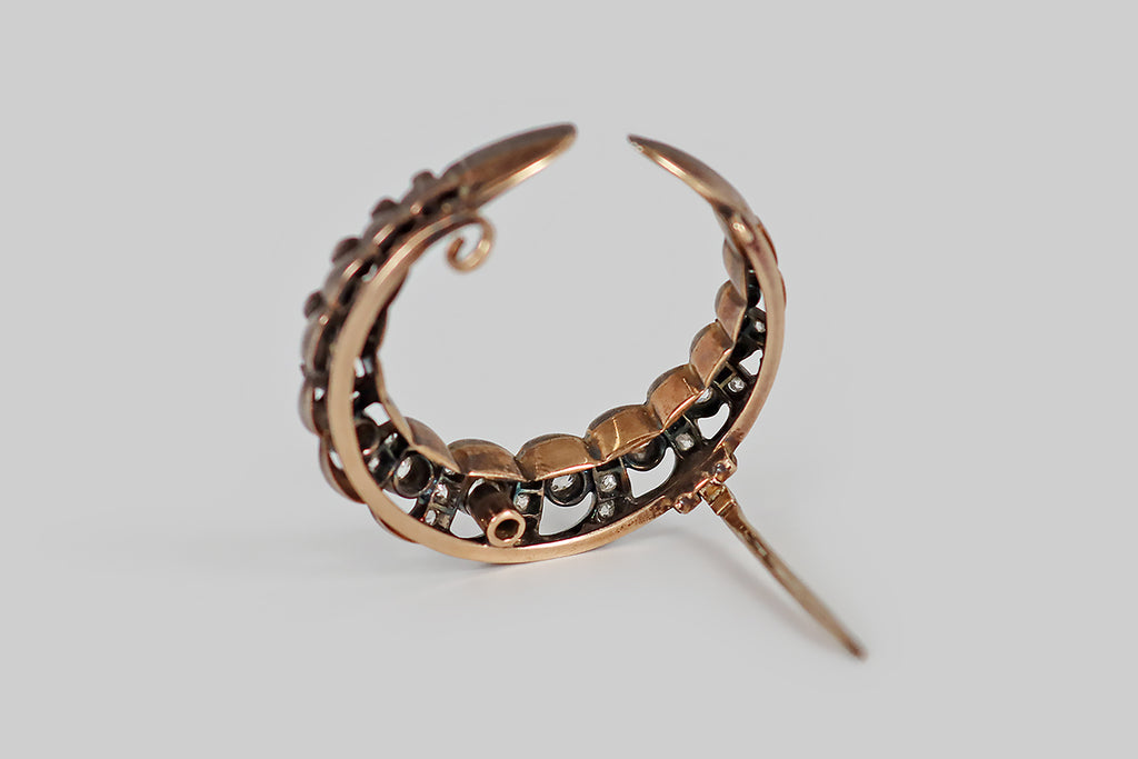 Poor Mouchette | Curated Antique Jewelry, Vintage Jewelry & Engagement Rings | Portland, Oregon | A large, Victorian era, crescent moon brooch, modeled in 14k rose gold and silver, whose elegant, spiraling, openwork form is studded with chunky old mine cut diamonds. This crescent's spiral form is reminiscent of a twisted rope, or a unicorn's horn. The primary diamonds, here, are mounted in textured collets, and posted in the crescent's open spaces. 