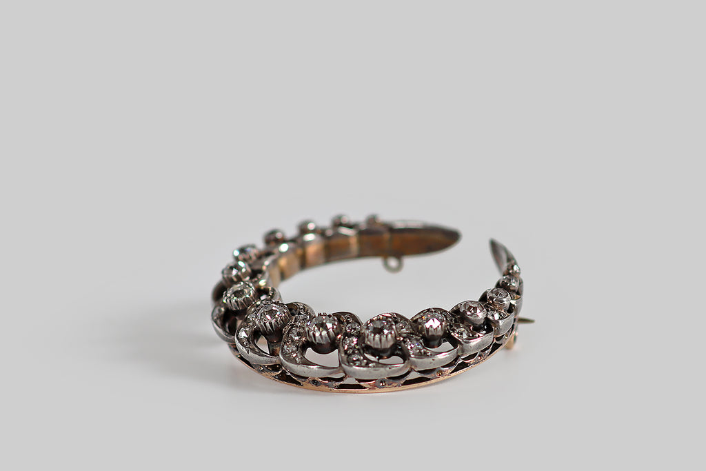 Poor Mouchette | Curated Antique Jewelry, Vintage Jewelry & Engagement Rings | Portland, Oregon | A large, Victorian era, crescent moon brooch, modeled in 14k rose gold and silver, whose elegant, spiraling, openwork form is studded with chunky old mine cut diamonds. This crescent's spiral form is reminiscent of a twisted rope, or a unicorn's horn. The primary diamonds, here, are mounted in textured collets, and posted in the crescent's open spaces. 