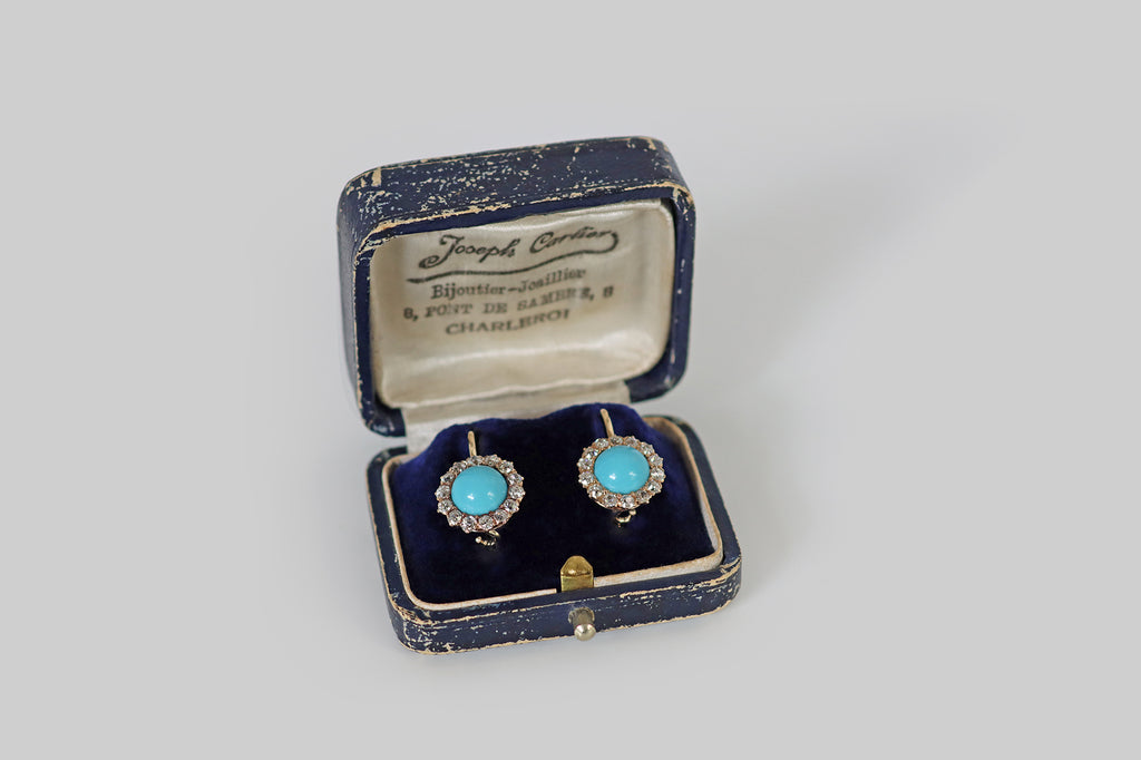 Antique Jewelry Portland, Vintage Jewelry Portland , Antique Engagement Rings | Poor Mouchette | A pair of Victorian era drop earrings, modeled in 14k yellow gold, whose primary gems are a pair of a large, round, Persian turquoise cabochons. These striking turquoise cabs are clear, vibrant, and sky-blue in color. They are surrounded by halos of chunky old European cut diamonds, which are white and very clean, with small, high tables, steep crown facets, and open culets.