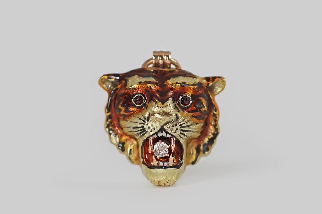 Antique Jewelry Portland, Vintage Jewelry Portland , Antique Engagement Rings | Poor Mouchette | A scarce, Victorian-era, three-dimensional tiger mask pendant, modeled in 14k gold and beautifully painted with vitreous, polychrome enamel, in various shades of red, orange, brown, yellow, black, and white. This tiger is especially handsome, and he is highly-detailed. He wears an intense expression, and holds a small old mine cut diamond