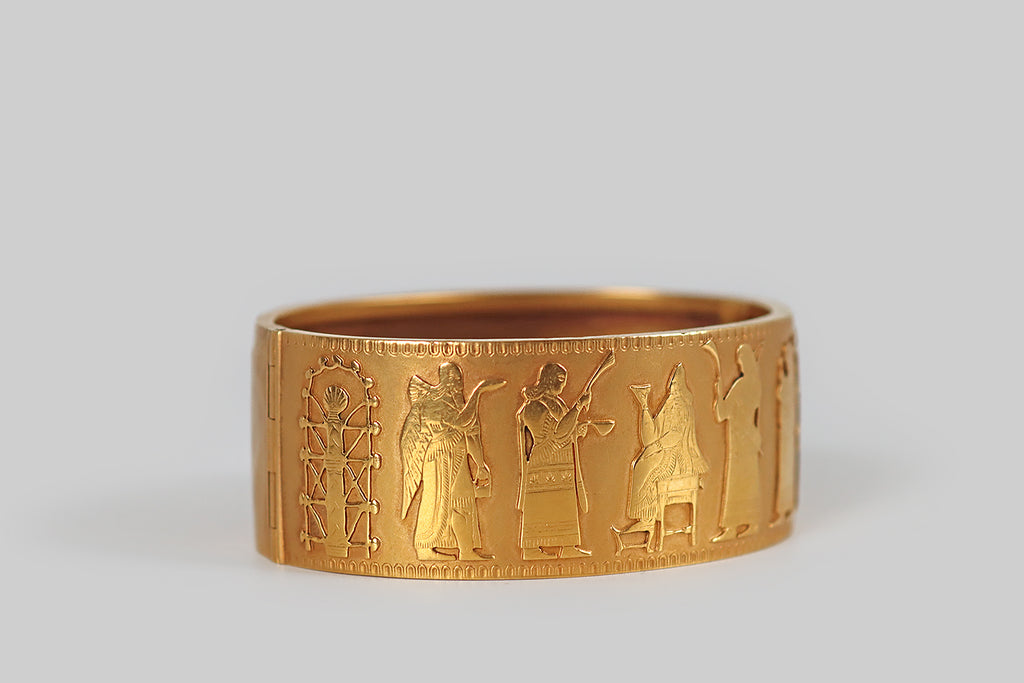 Antique Jewelry Portland, Vintage Jewelry Portland , Antique Engagement Rings | Poor Mouchette | A rare and wonderful 19th century Assyrian Revival bracelet, modeled in 18k gold, whose face is decorated with pierced and applied figures that depict an Assyrian court scene (copied from a famous Gypsum panel that was excavated at the city of Nimrud, from the palace of King Ashurnasirpal II). These figures were hand pierced from gold sheet, and finely engraved with the details of their embroidered clothing