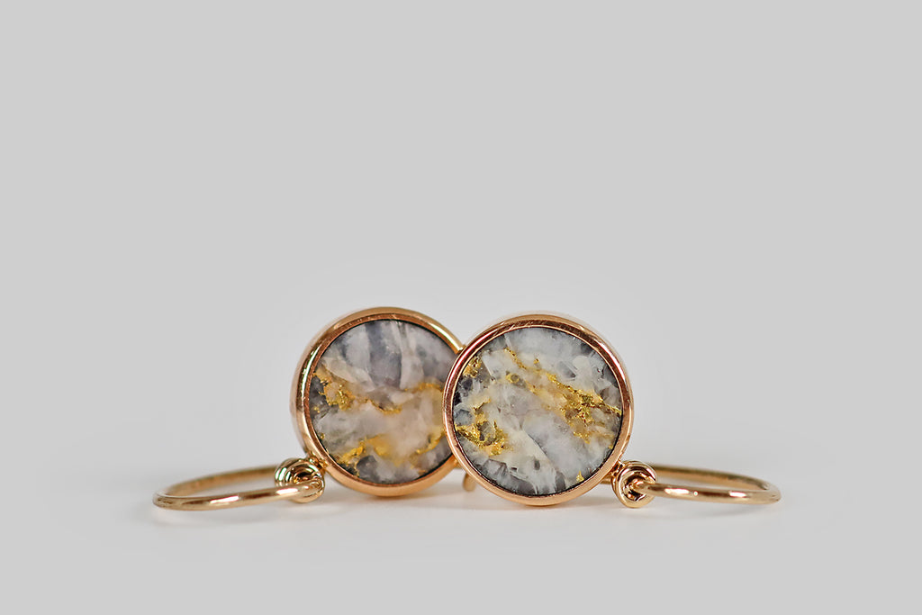 Antique Jewelry Portland, Vintage Jewelry Portland , Antique Engagement Rings | Poor Mouchette | A very cool pair of Victorian-era drop earrings, modeled in 14k rose gold, whose drops are petite, circular, gold-in-quartz slabs, set in low-profile, closed-back bezels. These little circles have an icy grey/white field, with beautiful marbled figuring, across which dramatic, vibrant-yellow splashes of native gold are dispersed.