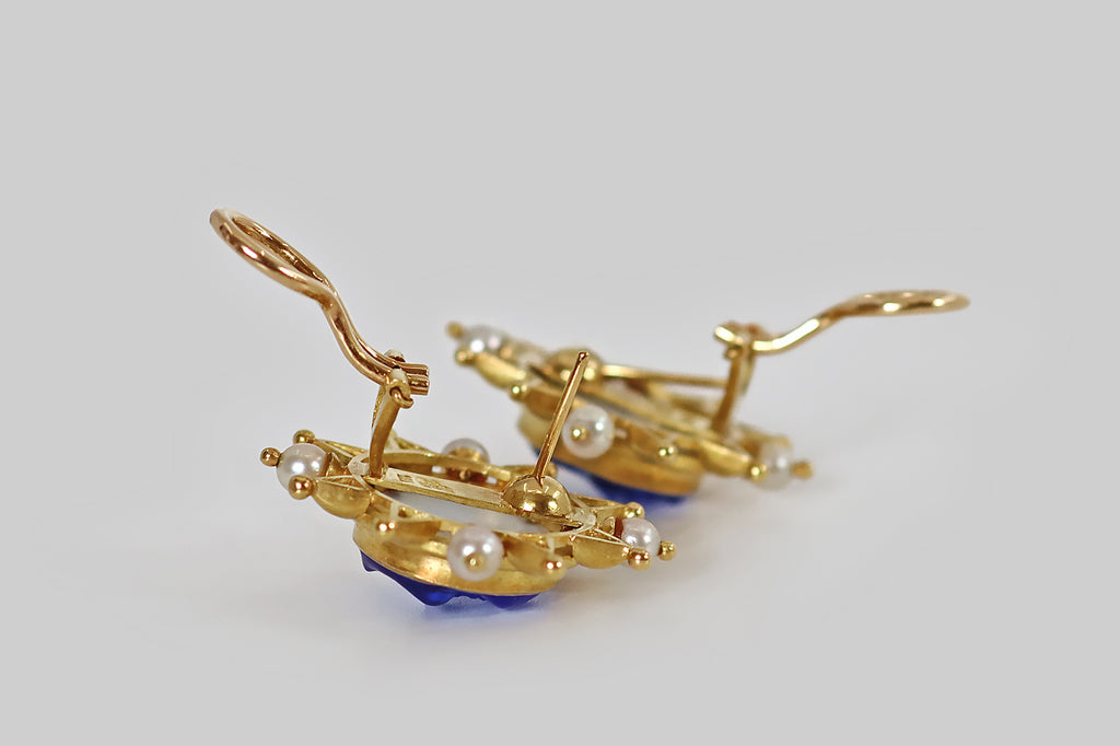 Antique Jewelry Portland, Vintage Jewelry Portland , Antique Engagement Rings | Poor Mouchette | A striking pair of large, late-vintage, Elizabeth Locke earrings, modeled in 18k yellow gold, whose central elements are a pair of blue, venetian-glass sun faces. These faces are smiling, apple-cheeked, and they have a deep, ethereal glow, thanks to the mother of pearl discs that lay behind them. Heavy borders, decorated with chubby, triangular rays, surmount our shining faces, and each halo of rays 