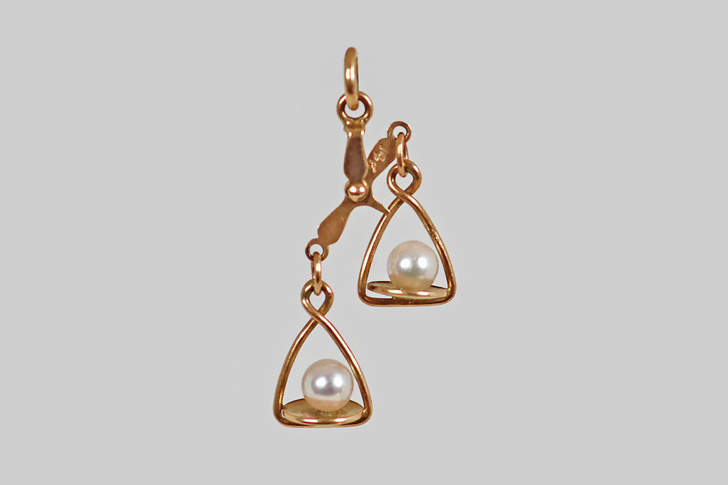Antique Jewelry Portland, Vintage Jewelry Portland , Antique Engagement Rings | Poor Mouchette | A dainty, vintage, articulated charm, modeled in 14k yellow gold, to resemble a pair of balance scales, with white, cultured-pearl weights. These tiny scales have pans that tip up and down, thanks to a beautifully-made, riveted apex that connects the scale's pillar and beam. This is a wondrous little object and it is beautifully made! 