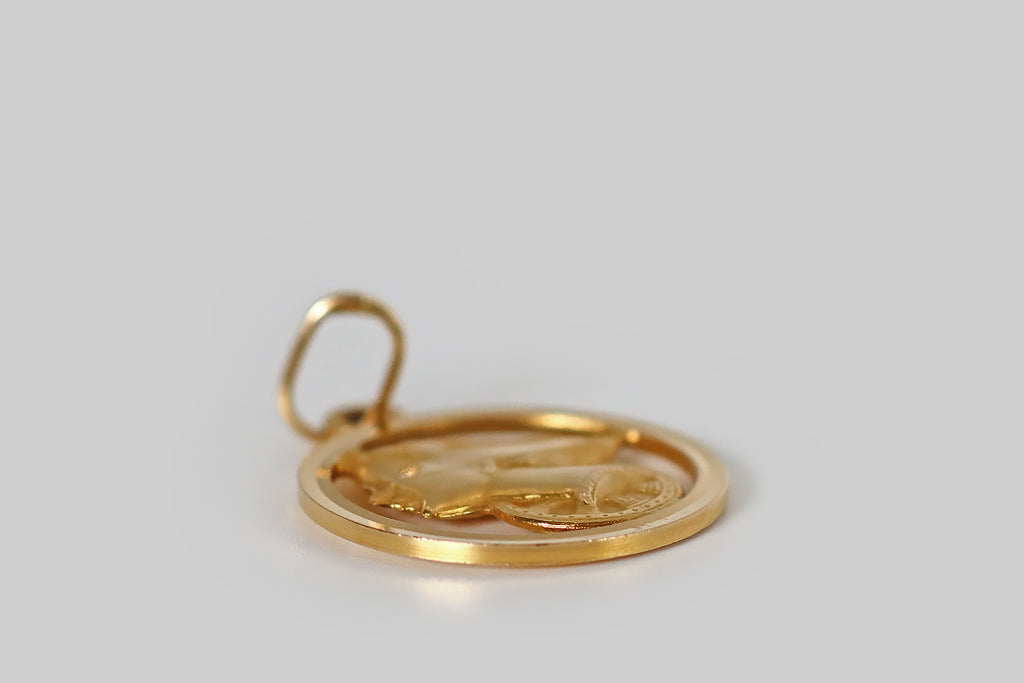 Poor Mouchette | Curated Antique Jewelry, Vintage Jewelry & Engagement Rings | Portland, Oregon | A vintage pendant, modeled in 18k yellow gold, featuring the bust of the Roman Goddess Fortuna and her wheel of fortune. Dea Fortuna is depicted, here, as a blindfolded woman with long, flowing hair⁠— she wears a carefree expression. The wheel of fortune is situated behind her, and a broad, circular frame encircles them both. This pendant has lovely dimensionality and depth. Both sides are fully finished