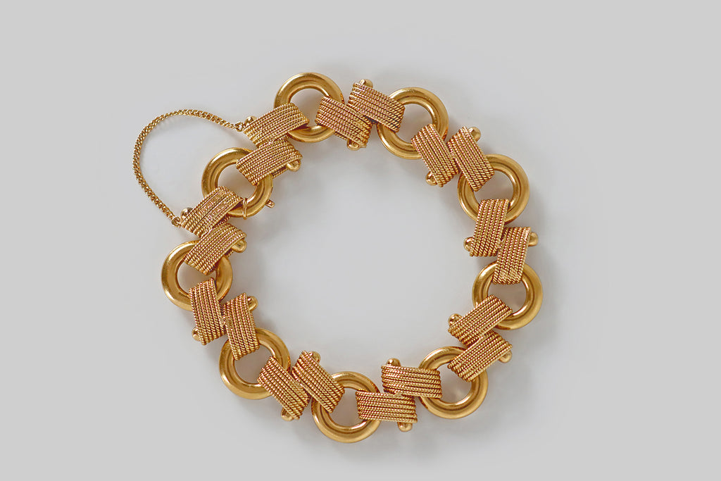 Poor Mouchette | Curated Antique Jewelry, Vintage Jewelry & Engagement Rings | Portland, Oregon | A beautiful, mid-twentieth-century bracelet by Tiffany &amp; Co., modeled in 18k yellow gold, whose links are a combination of thick, oversized rings, and off-set pairs of slender, flat-wound, twisted rope. These fancy, rope-like links are arranged around a large gold post— the way they pass over this bar, bypassing each other, before connecting to the bracelet's large rings, creates an impression of graceful