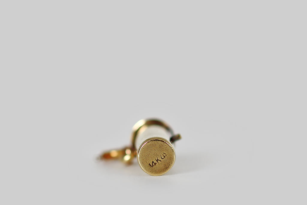 Antique Jewelry Portland, Vintage Jewelry Portland , Antique Engagement Rings | Poor Mouchette | A very cool, moveable, miniature charm, modeled in 14k yellow gold by the well-known New York jewelers Sloan & Co. This tiny hand-fabricated charm is made to resemble a tube of lipstick. Push the charm's button plunger upwards, and a knob of bright red enameled lipstick emerges from its gold case; push it down, and the make-up returns to the tube!