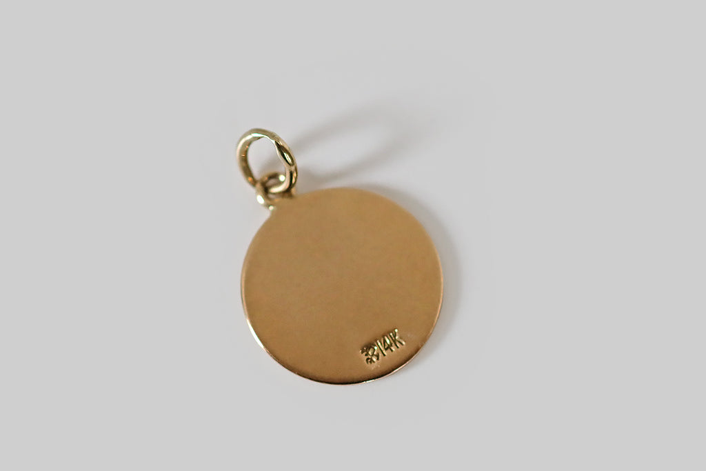 Antique Jewelry Portland, Vintage Jewelry Portland , Antique Engagement Rings | Poor Mouchette | A petite vintage zodiac charm, modeled in 14k yellow gold, by the Richardson Mfg. Co. This little disc shaped charm is decorated with a gentle bull, in black and off-white enamel— he lies in repose beneath Taurus's astrological glyph. We love the posture of the bull here, calling to mind the down-to-earth gentleness and patience associated with this sign
