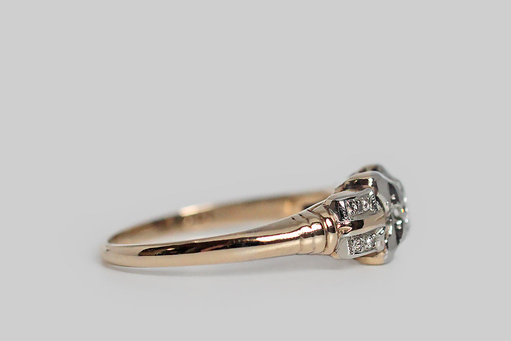 A charming, 1940s engagement ring, modeled in white and rosy-yellow 14k gold. This old darling features a transitional cut diamond, which is bead-set into the ring's unique, x-shaped face. Two pairs of diamond-studded epaulettes add interest to the ring's shoulders, along with a subtle ribbed detail. The half-round shank tapers toward the base. Marked 14k for purity.