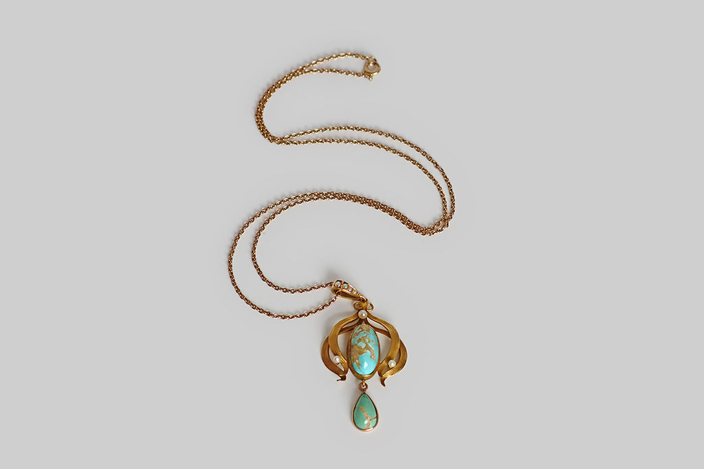 Poor Mouchette | Curated Antique Jewelry, Vintage Jewelry & Engagement Rings | Portland, Oregon | A lovely Art Nouveau era lavaliere necklace, modeled in 10k rosy yellow gold, whose pendant features two natural, bezel-set, turquoise cabochons— a robin’s egg blue oval, that rests inside the pendant's shapely gold frame, and a slightly greener (sea foam) pear, that drops below this frame. These turquoise cabochons are vibrant and highly-silicated, with a high polish, and striking light-brown matrix.