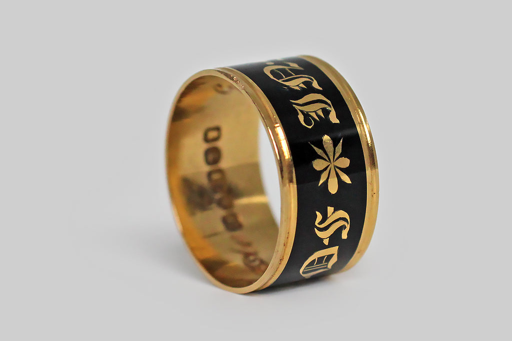 Poor Mouchette | Curated Antique Jewelry, Vintage Jewelry & Engagement Rings | Portland, Oregon | A beautiful, Georgian-era, wide band ring, modeled in 18k gold and decorated with black enamel. This broad, flat mourning band was made in memory of George Moody, and it is dated for the year 1818. This has a very subtle ribbed detail, at the lip, but its striking, clean lines are otherwise uninterrupted. The band's smooth, enameled face reads “in memory of,” in bold gothic script.