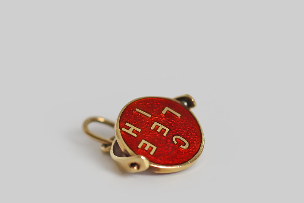 Antique Jewelry Portland, Vintage Jewelry Portland , Antique Engagement Rings | Poor Mouchette | A wonderful, early-20th-century enameled spinner charm, modeled in 14k yellow gold, whose central disc spins freely inside a stirrup-shaped "frame." This disc is decorated with bright red guilloche enamel. Gold letters from the phrase "ich liebe dich" 