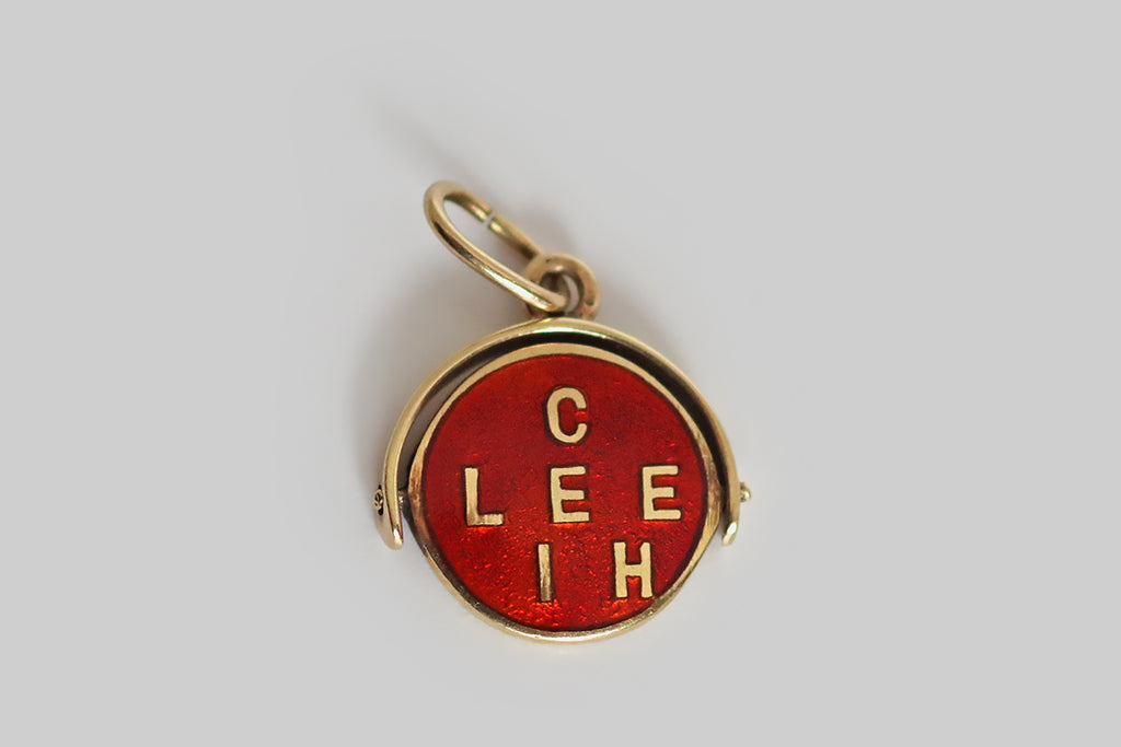 Antique Jewelry Portland, Vintage Jewelry Portland , Antique Engagement Rings | Poor Mouchette | A wonderful, early-20th-century enameled spinner charm, modeled in 14k yellow gold, whose central disc spins freely inside a stirrup-shaped "frame." This disc is decorated with bright red guilloche enamel. Gold letters from the phrase "ich liebe dich"