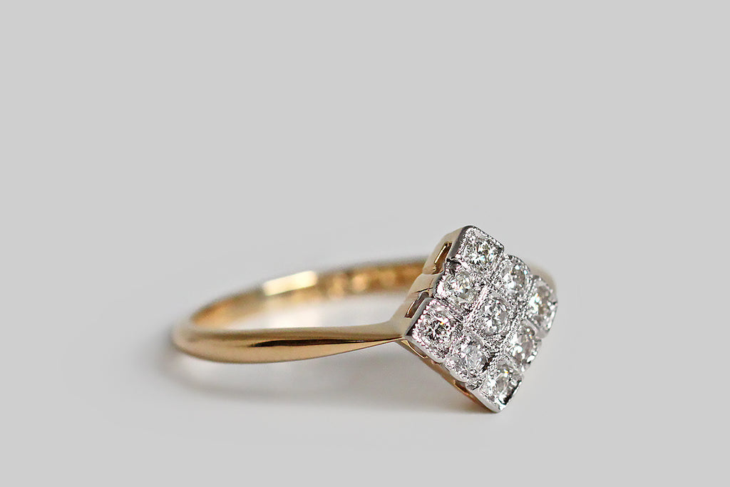 Poor Mouchette | Curated Antique Jewelry, Vintage Jewelry & Engagement Rings | Portland, Oregon | A charming, Art Deco era, diamond cluster ring, modeled in 18k yellow gold and platinum, with a diamond-shaped face. This elegant, low-profile ring is set with nine, sparkling, transitional cut diamonds— each of these gems is bead set into a square seat. These little diamond seats are crisp and distinct in the borderless ring face. They are separated by sparkling milgrain edges