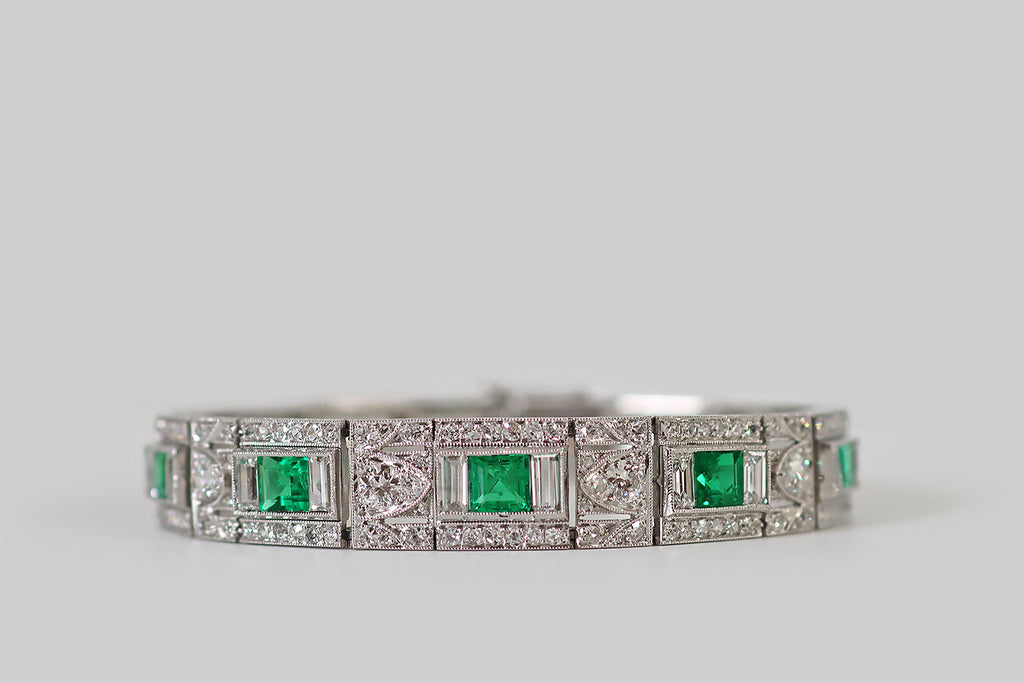 Antique Jewelry Portland, Vintage Jewelry Portland , Antique Engagement Rings | Poor Mouchette | An elegant Art Deco era bracelet, modeled in platinum, whose primary gems are a quintet of vibrant natural emeralds. These emeralds have rich, highly-saturated color and excellent transparency— they graduate in size, outward from the center. Each is set in a milgrained bezel, where they are flanked by pairs of baguette diamonds.