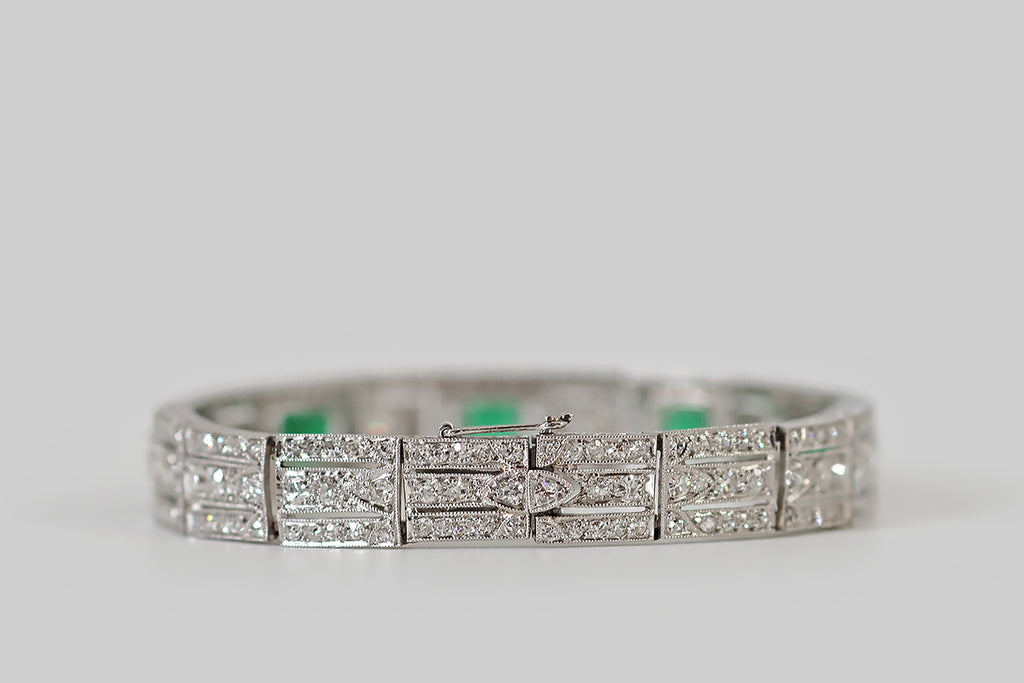 Antique Jewelry Portland, Vintage Jewelry Portland , Antique Engagement Rings | Poor Mouchette | An elegant Art Deco era bracelet, modeled in platinum, whose primary gems are a quintet of vibrant natural emeralds. These emeralds have rich, highly-saturated color and excellent transparency— they graduate in size, outward from the center. Each is set in a milgrained bezel, where they are flanked by pairs of baguette diamonds.