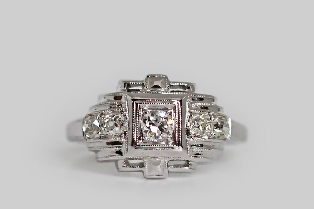 A charming, Art Deco era, five-stone engagement ring, modeled in platinum and set with approx .30 carats of lovely, old cut diamonds. This geometrically-inclined ring calls to mind a small, glittering temple (temple of your love perhaps!). The central transitional cut diamond weighs approx .10 carats