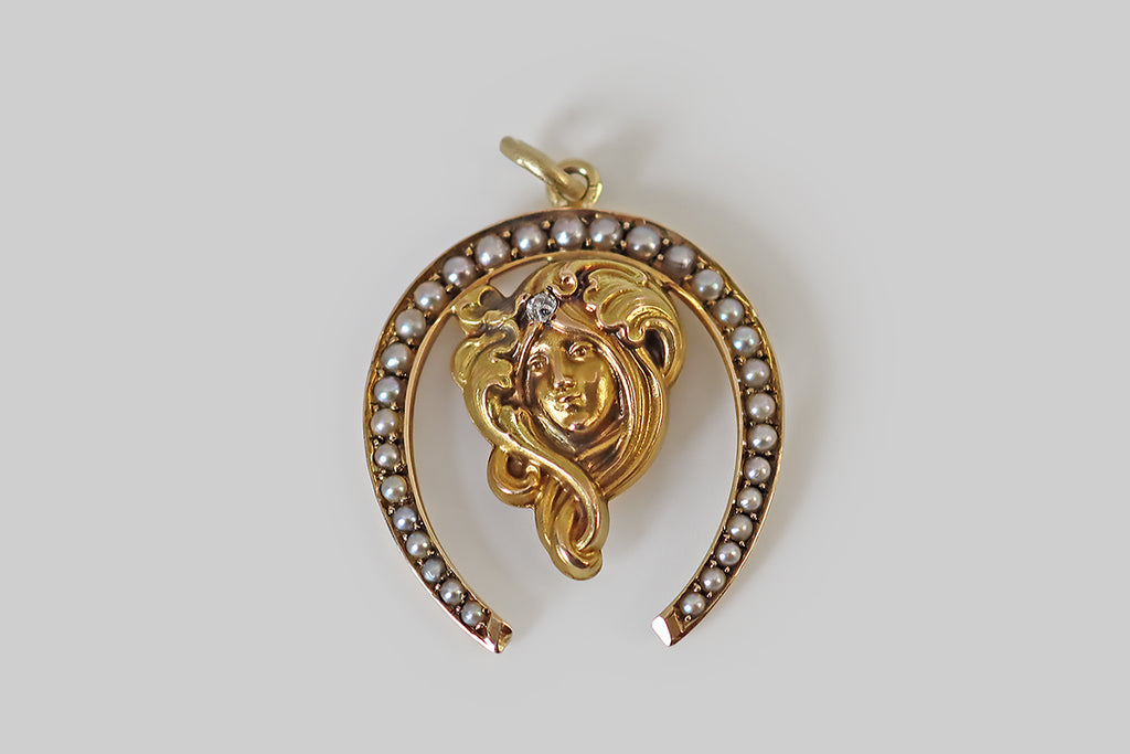 Antique Jewelry Portland, Vintage Jewelry Portland , Antique Engagement Rings | Poor Mouchette | A lovely Art Nouveau era pendant, modeled in 14k yellow gold, whose primary element is a maiden with a gentle, smiling expression. This carefully-sculpted lady has long flowing hair that twists under her chin, curving upwards to become a crown of flowers and plumes. She is also crowned with a single, sparkling, old mine cut diamond. 