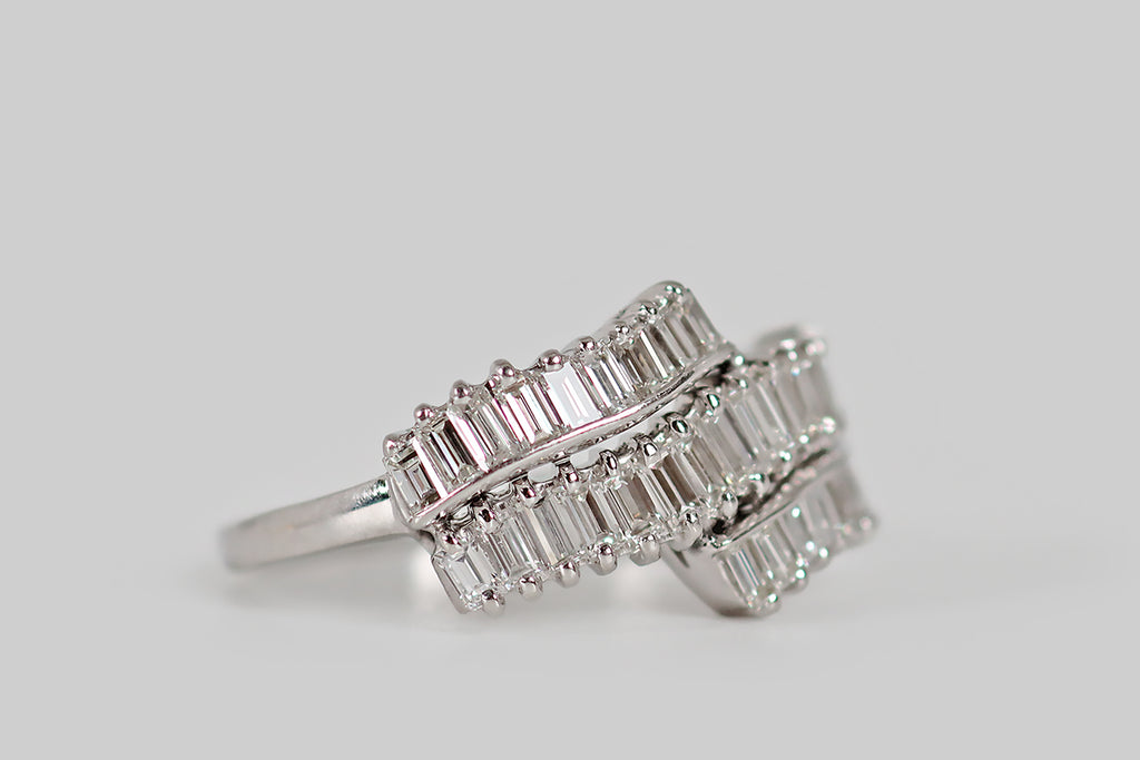 Antique Jewelry Portland, Vintage Jewelry Portland , Antique Engagement Rings | Poor Mouchette | A striking vintage cluster ring, modeled in platinum, whose face is decorated with three ribbon-like rows of beautiful baguette cut diamonds. These diamonds at arranged in an undulating manner— the central row of fifteen diamonds is framed by two "broken" rows of nine diamonds.