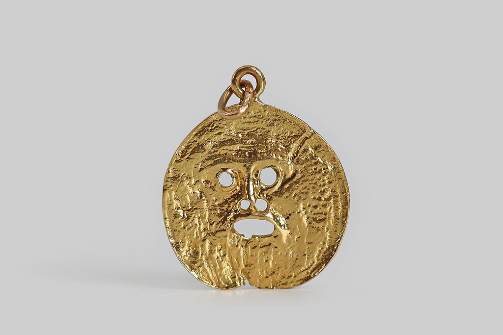 Poor Mouchette | Curated Antique Jewelry, Vintage Jewelry & Engagement Rings | Portland, Oregon | An unusual vintage pendant, modeled in 18k yellow gold, whose coin-like surface is sculpted with fine, varied, organic textures. The center of the pendant has been pierced to create a simple face, with an open mouth, which is meant to resemble Bocca Della Verità "The Mouth of Truth," a large, marble mask located in Rome, Italy. 