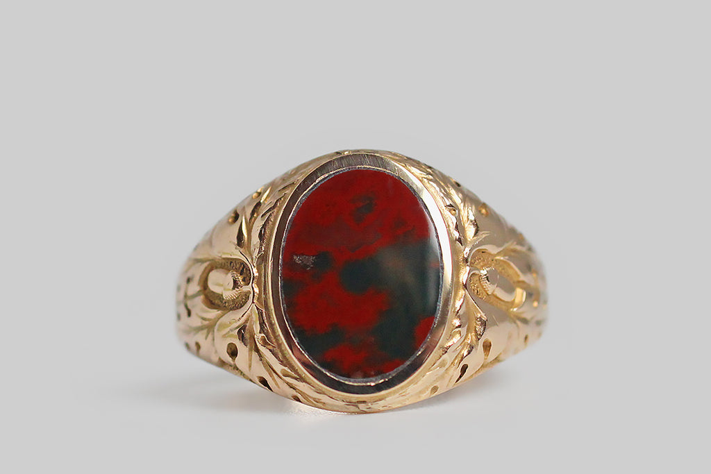 A striking, 1940s, bloodstone signet ring, modeled in 10k yellow gold, whose shoulders feature a deeply-carved decor of oak leaves and acorns. This carving is of very fine quality, with expressive lines, subtle variations, and a stippled ground that creates visual depth in the relief. Acorns symbolize growth and potential, while oak leaves stand for strength, endurance and fertility. Remember the old adage: all the wonder in a mighty oak grows from a single acorn.