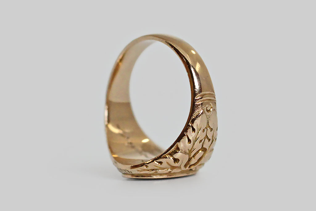 A striking, 1940s, bloodstone signet ring, modeled in 10k yellow gold, whose shoulders feature a deeply-carved decor of oak leaves and acorns. This carving is of very fine quality, with expressive lines, subtle variations, and a stippled ground that creates visual depth in the relief. Acorns symbolize growth and potential, while oak leaves stand for strength, endurance and fertility. Remember the old adage: all the wonder in a mighty oak grows from a single acorn.