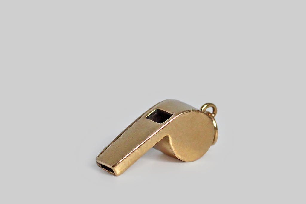 Poor Mouchette | Curated Antique Jewelry, Vintage Jewelry & Engagement Rings | Portland, Oregon | A dainty, mid 20th century charm, modeled in 14k yellow gold, as functioning, drill-style whistle. This tiny whistle is beautifully and substantially made, in the classic shape favored by coaches, police officers, and dog trainers, and it makes a soft, high-pitched sound when you blow it. 