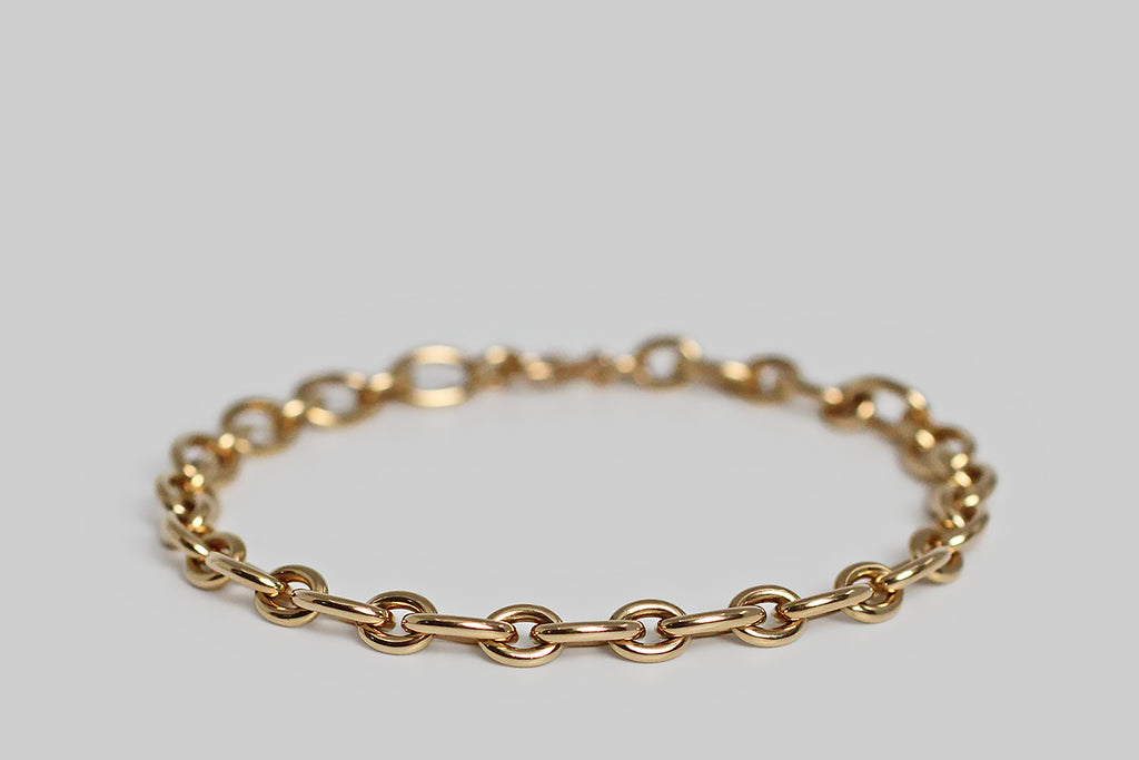 A weighty, mid twentieth century, 14k yellow gold cable link bracelet, comprised of long and short oval links. This bracelet is appealing for its minimalist design and beautiful, handmade construction. It has the soft, buttery glow that we love in vintage gold jewelry. This bracelet closes with a large bolt ring clasp. It makes a lovely, effortless statement, worn alone; it would also be a perfect foundation for a collection of charms.