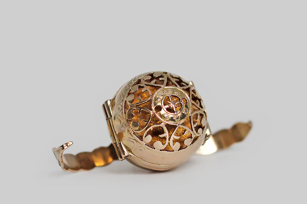 Poor Mouchette | Curated Antique Jewelry, Vintage Jewelry & Engagement Rings | Portland, Oregon | A clever, Victorian era, multi-photo locket, substantially modeled in 14k yellow gold, whose orb-like form is hand-pierced with a series of baroque heart shapes and a central medallion featuring a compass rose. This unusual, unfolding locket is bound by a pair of arms that snap into place, securing the orb