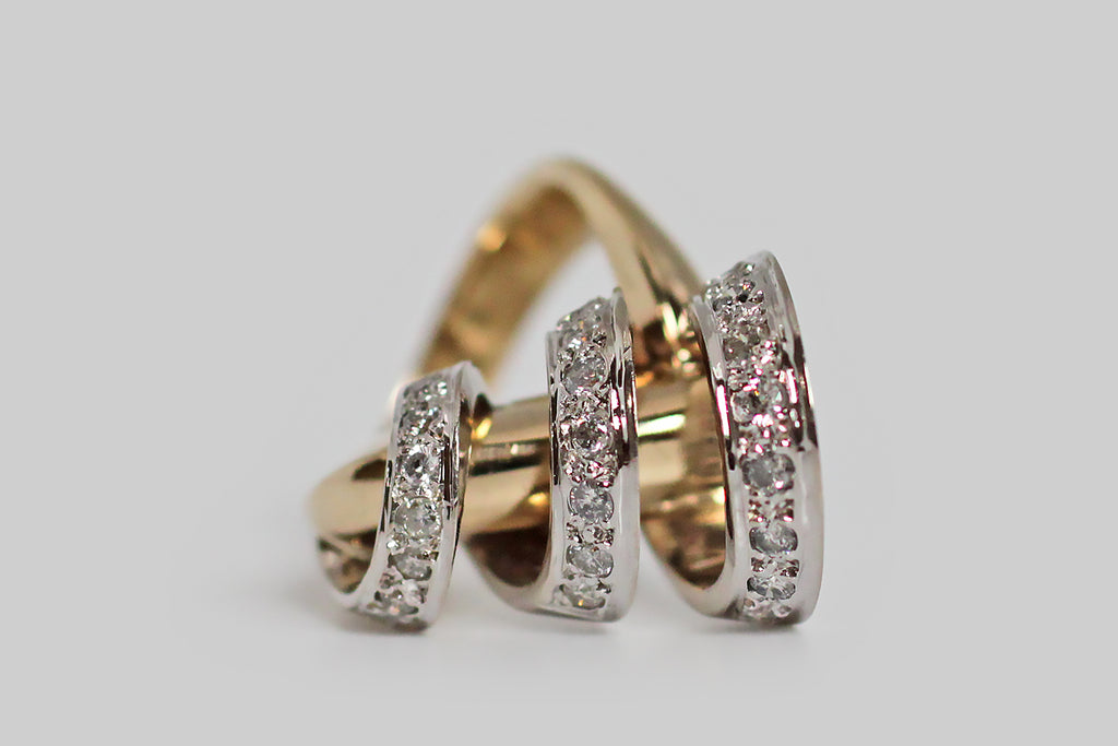 A vintage modernist ring, modeled substantially in 14k gold, whose unusual figure can be compared to a diamond-encrusted cyclone. The ring head’s open, spiraling white gold form whorls around a weighty, diagonally-placed, yellow gold rod— the graduating white gold form is highly-dimensional and is enlivened by many bead-set white diamonds. 