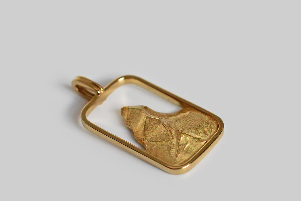 Poor Mouchette | Curated Antique Jewelry, Vintage Jewelry & Engagement Rings | Portland, Oregon | A bold, graphic, late-vintage pendant, modeled in 18k yellow gold, whose rectangular frame holds a modern-feeling likeness of the Matterhorn, the famous pyramidal mountain in the Swiss Alps. This pendant is thoughtfully carved and beautifully finished— its frame and hanging bail are polished, while the mountain's "facets" feature directional textures and a contrasting matte finish.