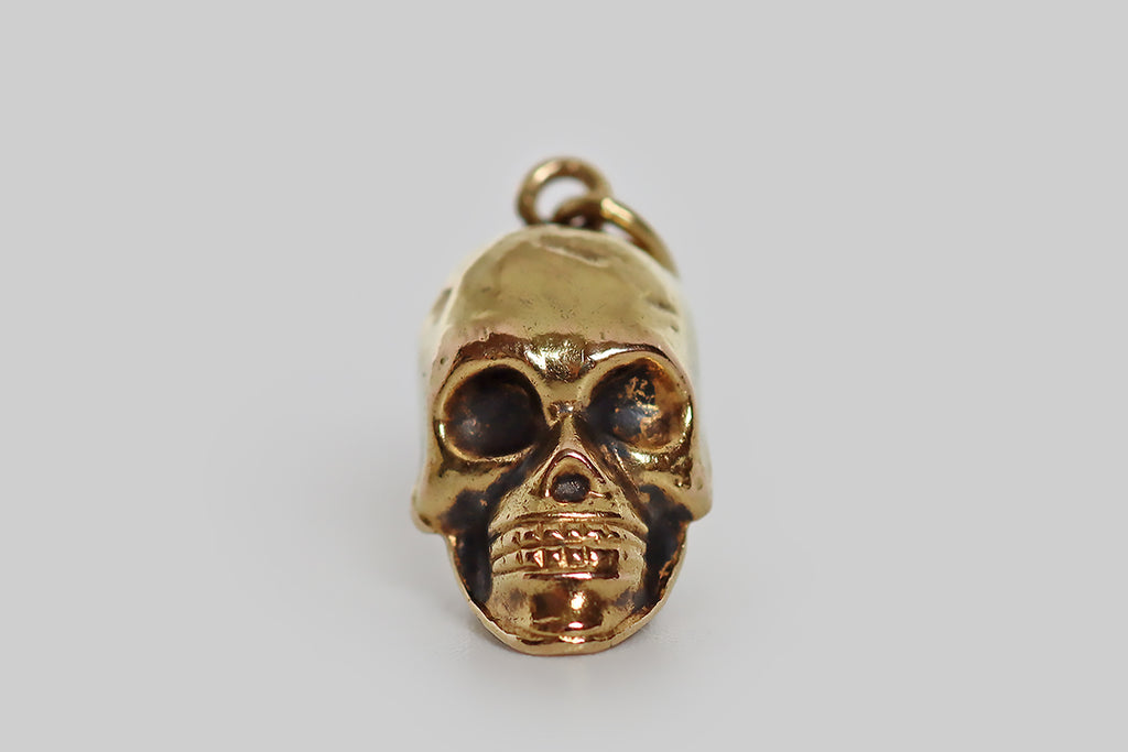 Poor Mouchette | Curated Antique Jewelry, Vintage Jewelry & Engagement Rings | Portland, Oregon | A rare and wonderful, miniature, early-20th-century charm, modeled in 14k gold, that takes the form of an especially handsome human skull! This antique skull charm is a partly hollow cast, with deep eye cavities, prominent cheek bones, a sharp jawbone, and two full rows of teeth. Patches of black patina give this gruesome old gent extra dimensionality and authenticity. He is a beautiful, weathered specimen! 