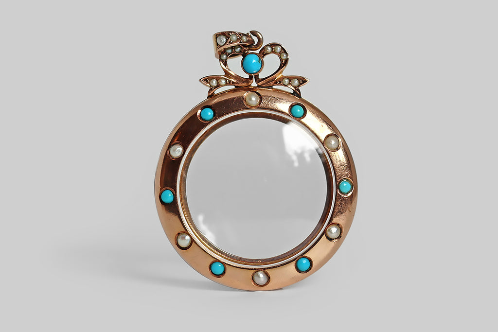 Poor Mouchette | Curated Antique Jewelry, Vintage Jewelry & Engagement Rings | Portland, Oregon | A charming, Edwardian era locket, modeled in 9k rose gold, and topped with a shapely bow. This two-crystal locket is made with a gold frame— this smooth frame is studded with a single row of bezel-set, natural turquoise cabochons and seed pearls, that alternate, blue/white, blue/white. The locket's bow decoration 