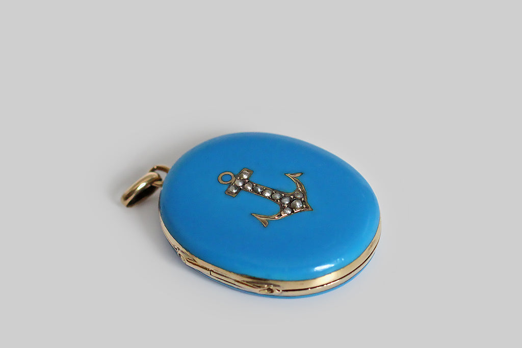 Poor Mouchette | Curated Antique Jewelry, Vintage Jewelry & Engagement Rings | Portland, Oregon | A lovely, Victorian-era locket, modeled in 14k yellow gold, whose front and back sides are swathed in bright, kingfisher-blue enamel. This medium-sized, oval locket bears a charming anchor motif on its face, and this anchor is set with a handful of natural, silvery seed pearls. A pair of tin type photos rest inside the locket, under glass— a man and woman wearing serious expressions.