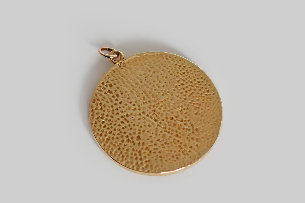 Poor Mouchette | Curated Antique Jewelry, Vintage Jewelry & Engagement Rings | Portland, Oregon | A very cool, extra-large, mid 20th century pendant, modeled in 14k yellow gold, whose subject is the water bearer, an image that represents the astrological sign Aquarius (January 20 - February 18). Our female water bearer has wavy, shoulder-length hair. Here, she kneels, in profile, surrounded by four stars and a crescent moon, pouring water from a vessel.