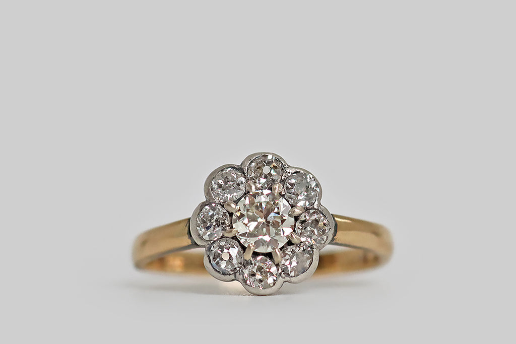 Poor Mouchette | Curated Antique Jewelry, Vintage Jewelry & Engagement Rings | Portland, Oregon | A striking, Victorian-era, cluster ring, modeled in silver and 14k yellow gold, whose nine old cut diamonds come together in the form of a flower. The chunky, old mine cut diamonds that make up the petals of this flower are set in silver collects. The central, .32 carat old European cut diamond (G/H, VS) is held in eight, claw-like, silver prongs.