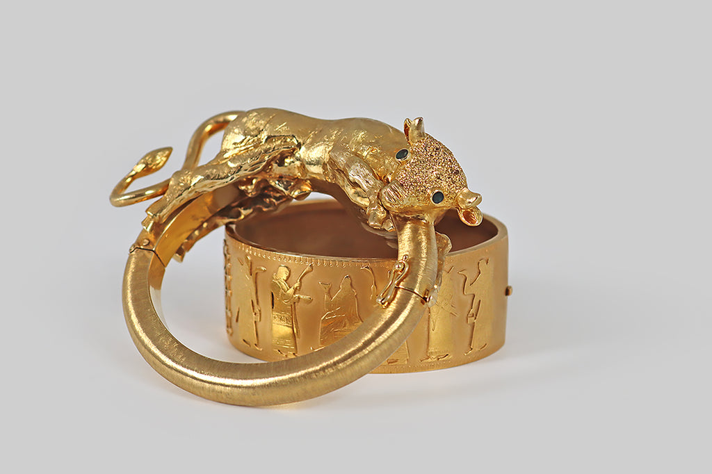 Poor Mouchette | Curated Antique Jewelry, Vintage Jewelry & Engagement Rings | Portland, Oregon | A monumental, 1970s, hinged bracelet, modeled in 18k yellow gold, across whose chunky half-round base a big, beautiful bull lounges. Our sweet beast is fully sculpted in three dimensions— he is sinewy, expressive, and muscular, but his posture is gentle. His underside is finished with a high polish, while his topside features fine, Florentine textures that recall a bull's smooth fur.