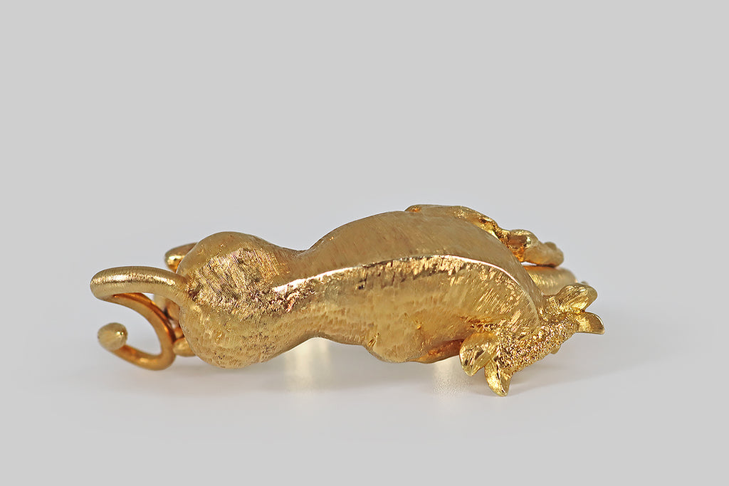 Poor Mouchette | Curated Antique Jewelry, Vintage Jewelry & Engagement Rings | Portland, Oregon | A monumental, 1970s, hinged bracelet, modeled in 18k yellow gold, across whose chunky half-round base a big, beautiful bull lounges. Our sweet beast is fully sculpted in three dimensions— he is sinewy, expressive, and muscular, but his posture is gentle. His underside is finished with a high polish, while his topside features fine, Florentine textures that recall a bull's smooth fur.